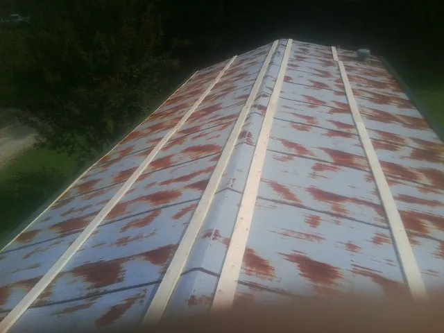 Rusted metal roof panels with new wood purlins before replacement — Storm Damage Roof Repair in Zapata by Roofing Brothers