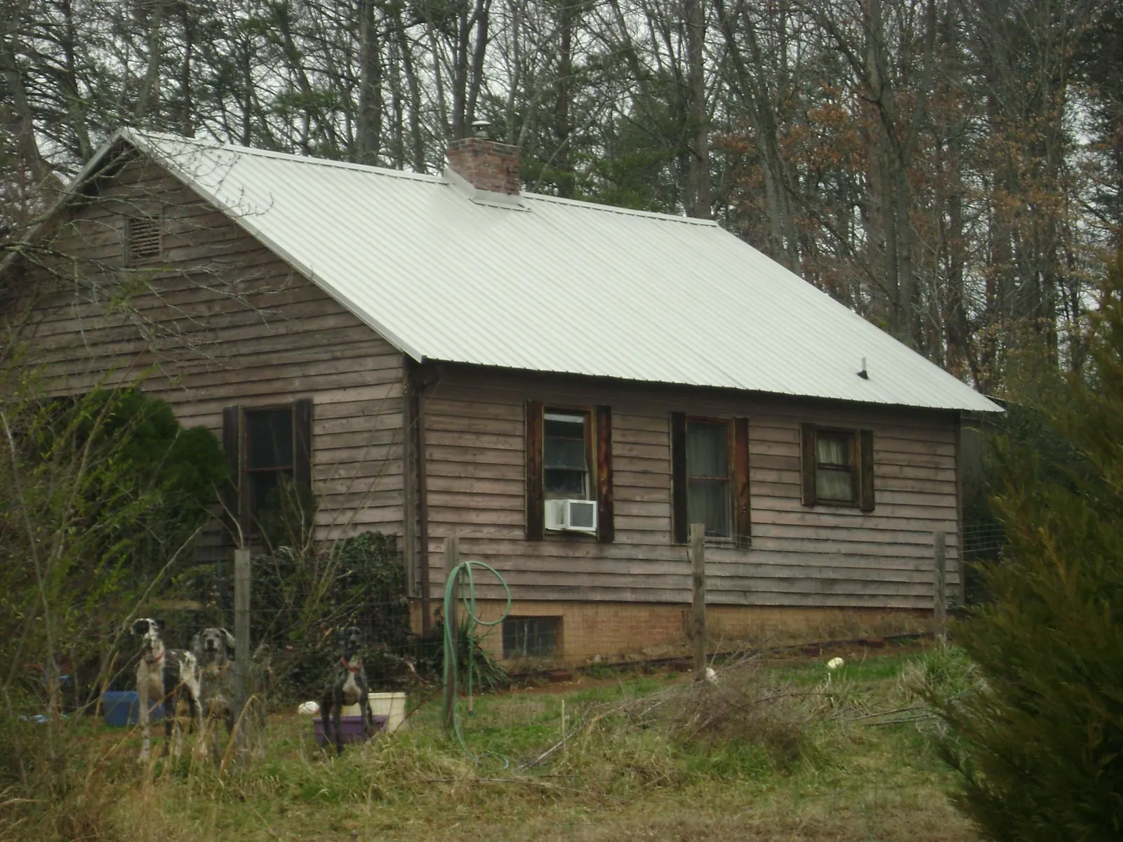 White metal roof on an old wood sided farmhouse, from a Metal Roof Installation job in Zapata